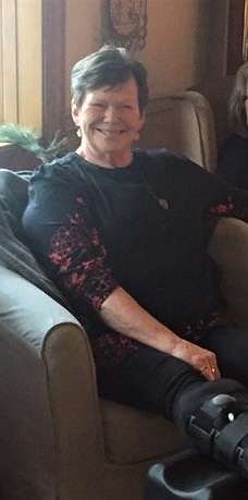 Sharon seated with an ankle boot